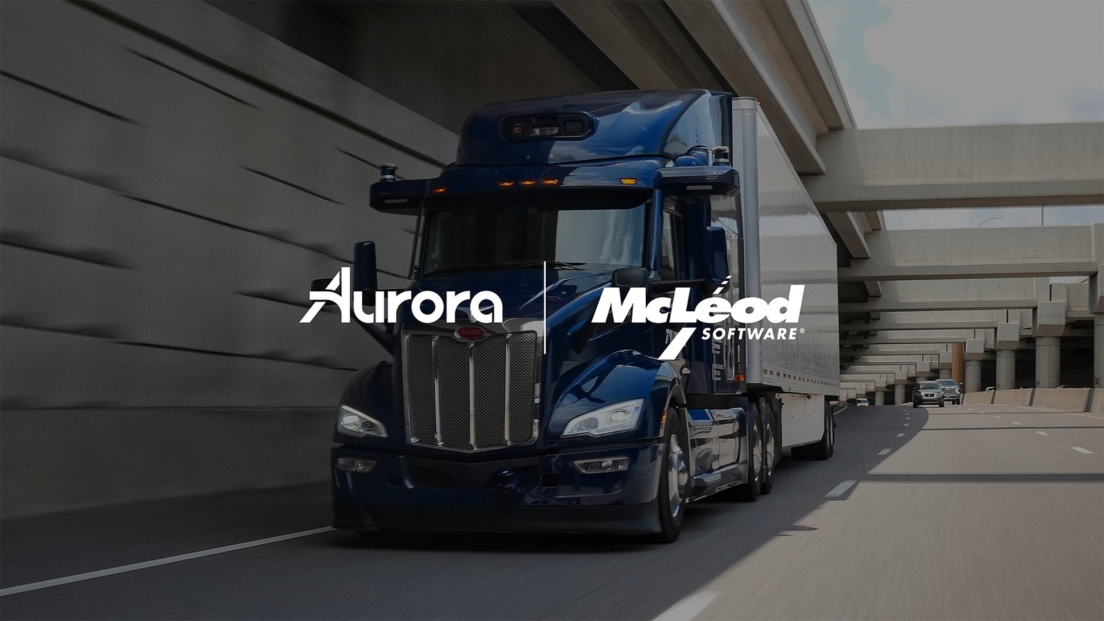 TechDogs-"An Image Of The Logos Of Aurora And McLeod Software With An Aurora Truck In The Background"